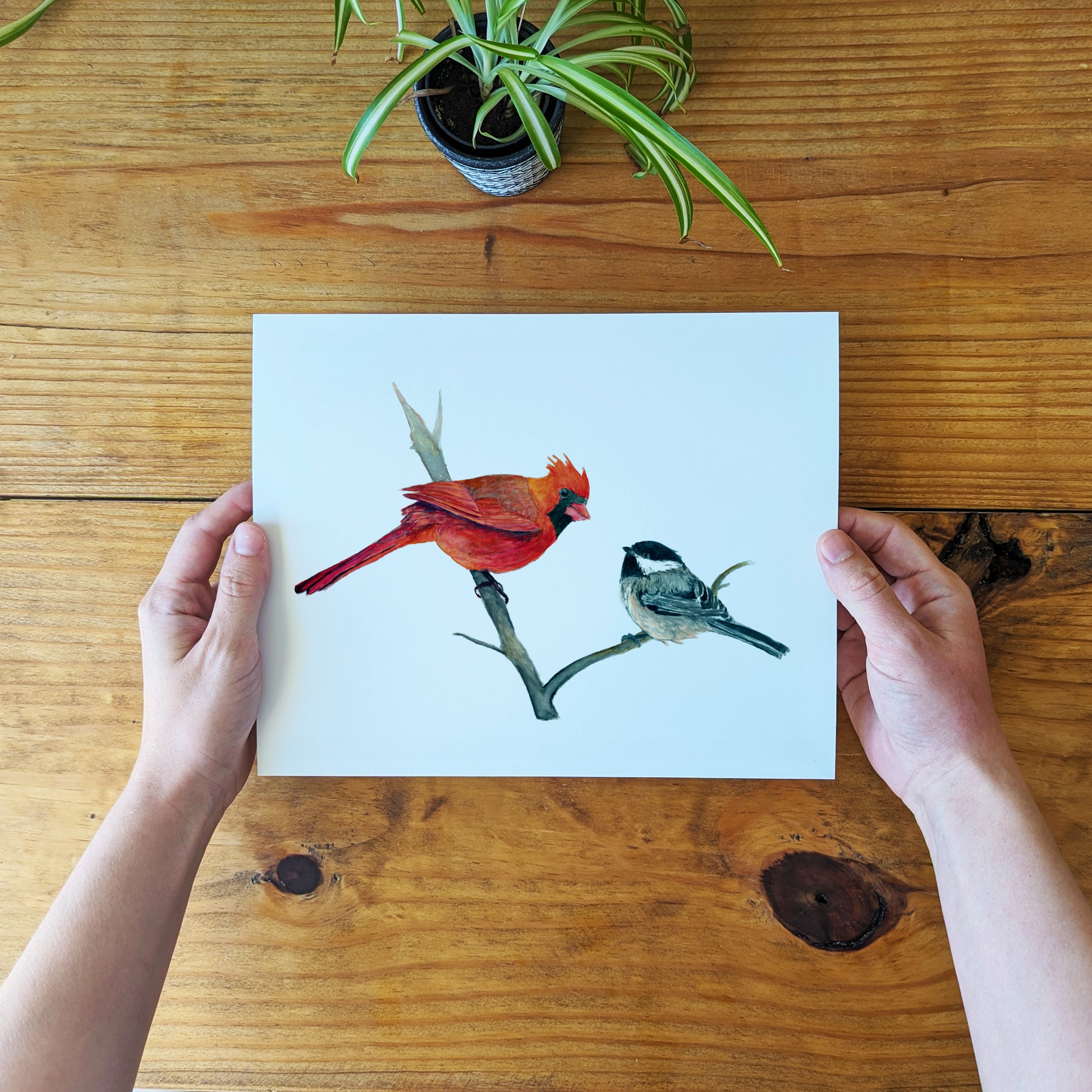 a person holding a card with two birds on it