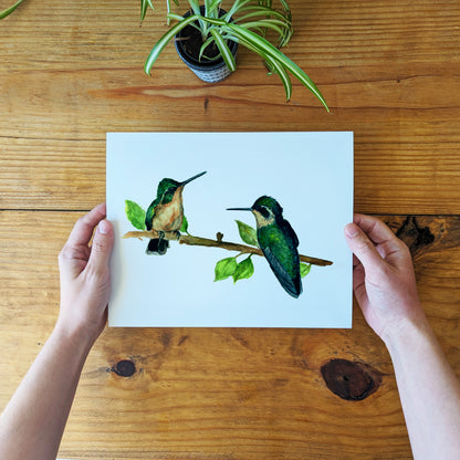 a person holding a card with two birds on a branch
