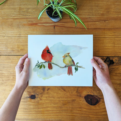 a person holding a card with two birds on it