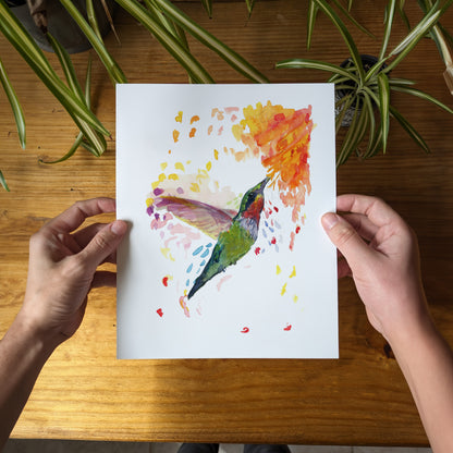 a person holding a piece of paper with a painting of a hummingbird on it