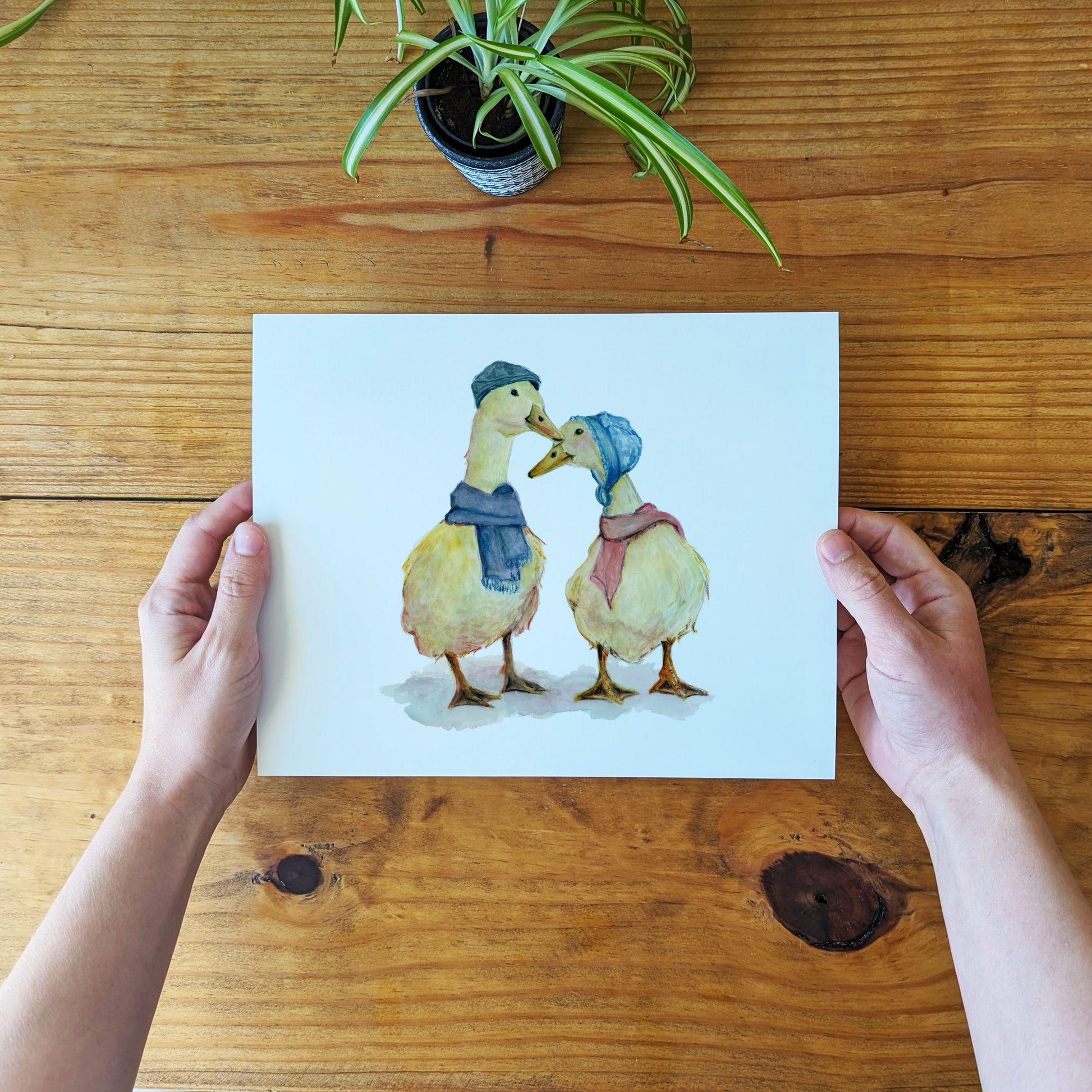 a person holding a card with two ducks on it